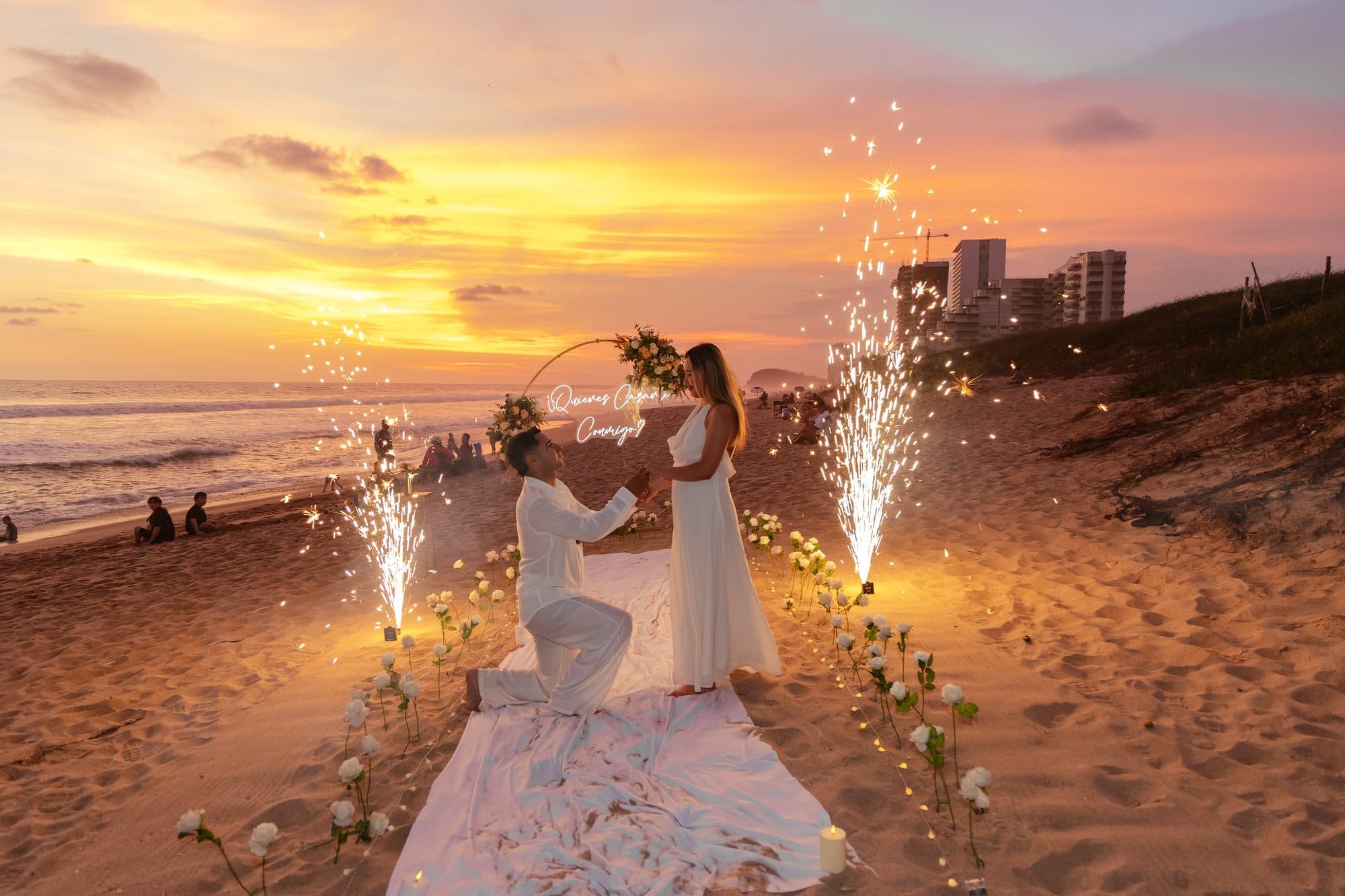 Propuesta de matrimonio en la playa con el sol del atardecer